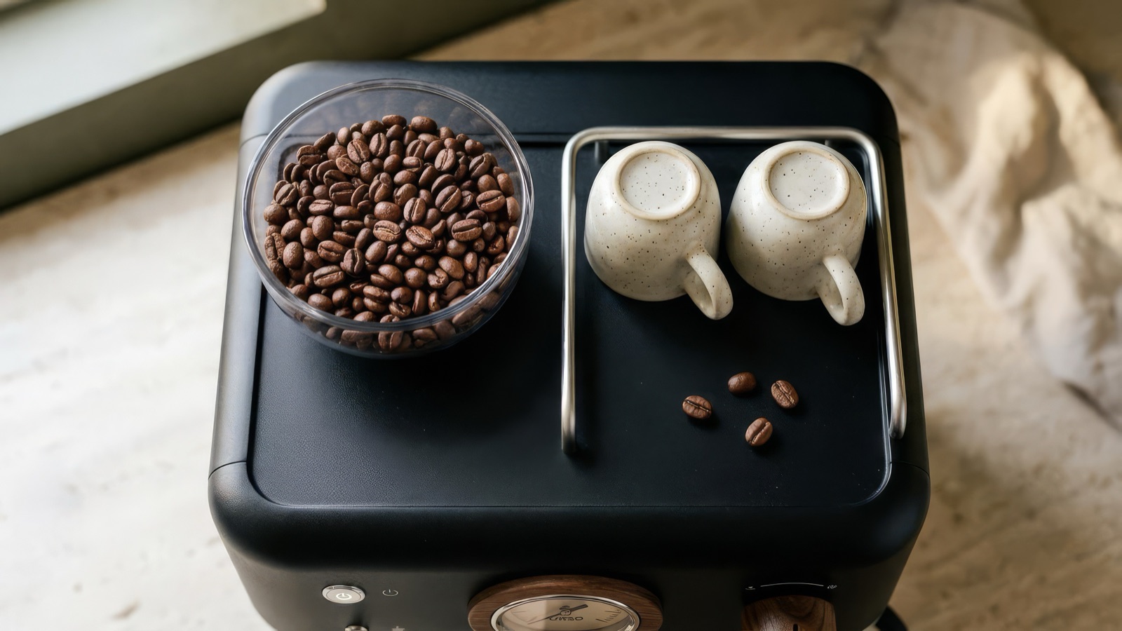 Top-down view of the glass bean hopper and two upside-down cups on the machine